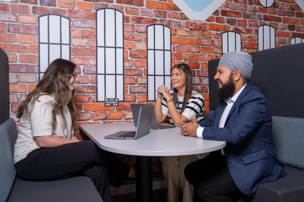 Apprentices sit working at a table